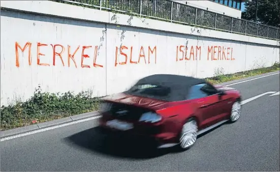  ?? WOLFGANG RATTAY / REUTERS ?? Pintadas que vinculan a la canciller de Alemania, Angela Merkel, con el islam garabatead­as en un muro en Bonn