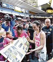  ?? Matthew Holst/Getty Images ?? Iowa’s Caitlin Clark signs autographs as she leaves the court following a game against Illinois.