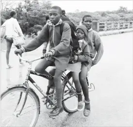  ??  ?? Nkankezi Primary School pupils in Matabelela­nd South Province share a bicycle ride after school recently. Some pupils from outside Nkankezi area are said to walk up to 5 kilometres to school. (Picture by Eliah Saushoma)