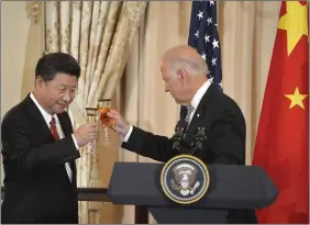  ?? REUTERS ?? This September 25, 2015 photo shows Chinese President Xi Jinping (L) and the then US Vice President Joe Biden raise their glasses in a toast during a luncheon at the State Department, in Washington, DC.