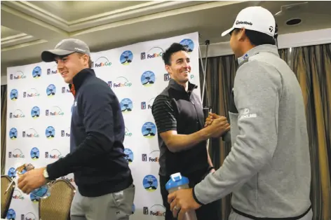  ?? Michael Macor / The Chronicle ?? Jake Owen ( center), playing partner of top- ranked golfer Jordan Spieth ( left), greets Jason Day at a Pebble Beach news conference.