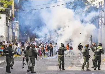  ?? Yuri Cortez AFP/Getty Images ?? POLICE CLASH with protesters who took to the streets of Caracas to oppose President Nicolas Maduro.