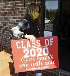  ?? BEN HASTY — MEDIANEWS GROUP ?? Denise Benfield holds a sign that she and Carrie McCarty had printed to honor graduating seniors who will not have a graduation ceremony because of the coronaviru­s outbreak.