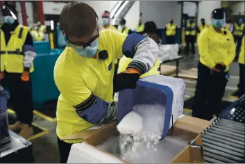  ?? MORRY GASH — THE ASSOCIATED PRESS ?? Dry ice is poured into a box containing the Pfizer-BioNTech COVID-19 vaccine as it is prepared to be shipped in Portage, Mich., on Sunday.