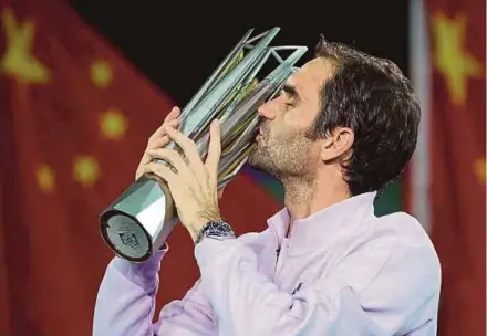  ?? REUTERS PIC ?? Roger Federer kisses the trophy after beating Rafael Nadal in Shanghai yesterday.
