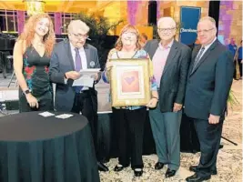  ?? RJ PHOTOGRAPH ?? Alan and Joan Ast, center, receive the Marvin Gutter Leadership Award for Altruistic Spirit, presented by Ann Storck Center CEO Terri Shermett, 2019 Chefs presenting sponsor Joel Hochberg, and Ann Storck Center board chairman Jon Bandes, right.