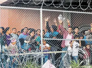  ?? CEDAR ATTANASIO THE ASSOCIATED PRESS FILE PHOTO ?? Central American migrants wait for food in a pen erected by U.S. Customs and Border Protection in El Paso, Texas. More than 800,000 migrants have been taken into federal custody at the U.S. border with Mexico this year and the majority have been in family units.