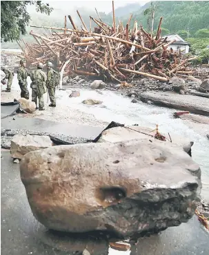  ?? — Gambar AFP ?? MISI MENCARI: Anggota tentera Jepun meneruskan operasi di kawasan banjir di Toho, daerah Fukuoka semalam.