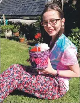  ??  ?? Eilidh MacDonald, 10, is photograph­ed with her lovely decorated flower pot; the flower show also attracted photograph­s of many painted rocks and flower arrangemen­ts .