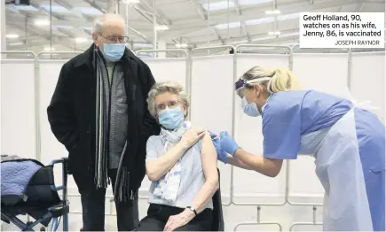  ?? JOSEPH RAYNOR ?? Geoff Holland, 90, watches on as his wife, Jenny, 86, is vaccinated