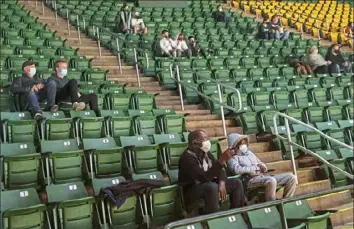  ?? Patrick Smith/Getty Images ?? Fans wear protective face masks and sit socially distanced Jan. 13 during a George Mason game against La Salle at Eagle Bank Arena in Fairfax, Va.