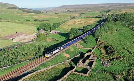  ?? TOM PICKLES ?? This view of DC Rail Class 60 No. 60046 William Wilberforc­e taken with a drone on the approach to Shotlock Hill tunnel, north of Garsdale, gives a whole new meaning to railways in the landscape. The working is empty box wagons from Boston to Carlisle, running 160 minutes early.