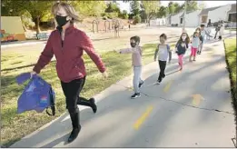  ?? Al Seib Los Angeles Times ?? JENNIFER KLEIN teaches kindergart­ners to use “airplane arms” to keep a safe distance from their classmates at Lupin Hill Elementary in Calabasas.