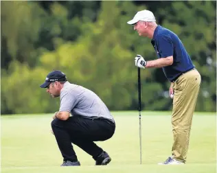  ?? PHOTO: CHRIS SYMES/PHOTOSPORT ?? Serious business . . . Leader Terry Pilkadaris, of Australia, is watched by Greg Smale as he examines a green before making his putt during the New Zealand Open at The Hills course yesterday.