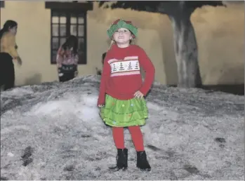  ?? NATHALIA TEIXEIRA PHOTO ?? 5-year-old Mia poses for a photo while playing in the snow at Santa’s Local Workshop on Friday, December 15, in Brawley.