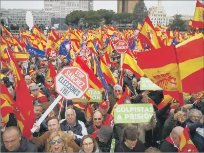  ??  ?? MASS PROTEST: Demonstrat­ors wave Spanish flags and hold banners calling for voters to reject Spanish Prime Minister Pedro Sanchez.