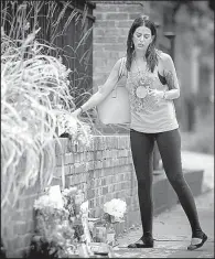  ?? AP/ Star Tribune/ ELIZABETH FLORES ?? A woman leaves flowers Monday at a makeshift memorial in Minneapoli­s at the scene where a Minneapoli­s police officer shot and killed Justine Damond of Australia.