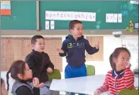  ??  ?? Right: A boy entertains his classmates during a language class.