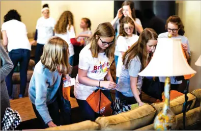  ?? Photos by Andy Calvert ?? Young volunteers, including Brighter Birthdays founder Cristin Walden’s kids, pack thousands of bags with a variety of gifts and treats for local kids. Cristin says many of the children who receive Brighter Birthday bags aren’t even aware that it’s...