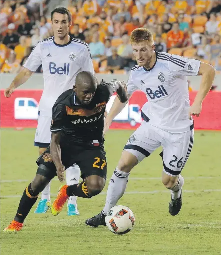  ?? — THE ASSOCIATED PRESS ?? Houston midfielder Oscar Garcia (27) explodes past Whitecaps defender Tim Parker (26) during secondhalf action on Saturday night. The teams played to scoreless tie.