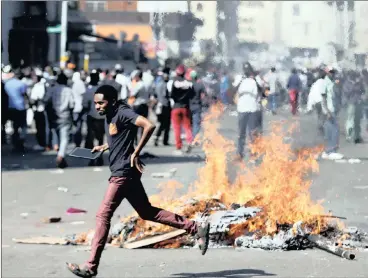  ?? PICTURE: REUTERS/ AFRICAN NEWS AGENCY (ANA) ?? A man runs past a burning barricade set alight by opposition supporters of Nelson Chamisa’s Movement for Democratic Change in Harare yesterday.