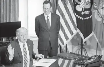  ?? Shawn Thew European Pressphoto Agency ?? MANY PROPOSALS in the report echo a bill passed by the House last week, but in some areas are more moderate. Above, President Trump and Treasury Secretary Steven T. Mnuchin at an April signing ceremony.