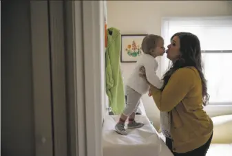  ?? Photos by Gabrielle Lurie / The Chronicle ?? Ashley Summers kisses daughter Alice Paulsen while getting her dressed. Summers’ boss, Supervisor Katy Tang, will propose a law with minimum standards for lactation spaces.