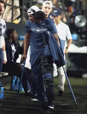  ?? Matthew Maxey / Icon Sportswire via Getty Images ?? UConn quarterbac­k Tyler Phommachan­h walks the sideline on crutches after suffering an injury at Vanderbilt in Nashville on Saturday.