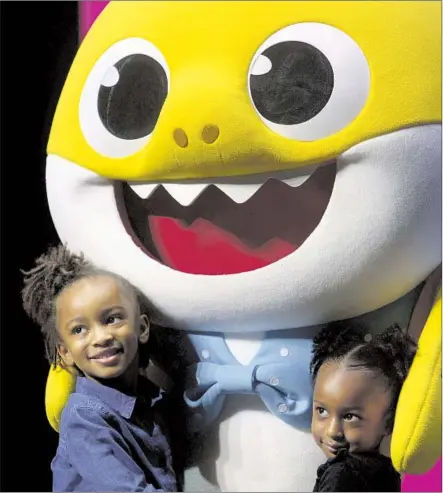  ?? Dania Maxwell Los Angeles Times ?? AT LONG BEACH’S Terrace Theater, sisters Anaiah, left, and Zariah Lafond pose with the star Saturday after “Baby Shark Live!”