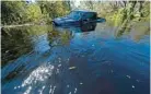  ?? HERBERT/AP GERALD ?? Floodwater flows through a swamped truck in a residentia­l neighborho­od in the aftermath of Hurricane Ian in North Port on Monday.