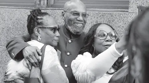  ?? AP ?? Muhammad Aziz (centre) stands outside the courthouse with members of his family after his conviction in the killing of Malcolm X was vacated, yesterday.