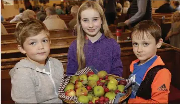  ??  ?? Powerscour­t NS pupils Noah Fortune, Laila Rose Allen McKee and Joe Maloney with fruit picked from the school grounds for the harvest service.