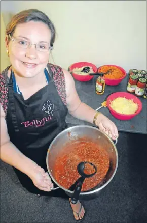  ??  ?? Cooking up a storm: The ground floor room at Pember House was a flurry of activity on Saturday, as Bellyful members, like Rebecca Morahan, were chopping, grating, stirring and cooking the next batch of meals.