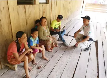  ??  ?? Wan (right) listens attentivel­y as a woman talks about the hardship living without water and electricit­y supply.