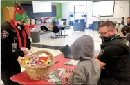  ??  ?? School Resource Officer Mindy Fowler handed out prizes to the students during the Shop with a Cop covid-style event last week. School Resource Officer Drew Rosser assisted one student with the games and shopping.