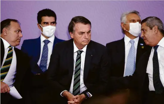  ?? Pedro Ladeira - 16.dez.20/Folhapress ?? Os ministros Eduardo Pazuello (Saúde), à esq., e Braga Netto (Casa Civil), à dir.; no meio, o presidente Jair Bolsonaro