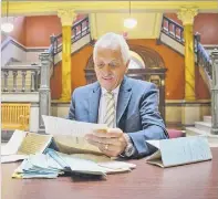  ?? Paul Buckowski / Times Union ?? Rensselaer County Clerk Frank Merola looks over “Legs” Diamond’s court records on the first floor of the Rensselaer County Court House in Troy.