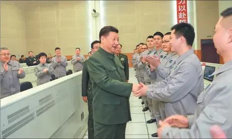  ?? LI GANG / XINHUA ?? President Xi Jinping, who also leads the Party and military, talks with scientists and technician­s about their research, work and lives as he visits a satellite launch center in Sichuan province on Saturday.