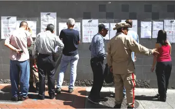  ?? — Reuters photo ?? People check electoral lists at a polling station during the municipal legislator­s election in Caracas, Venezuela.