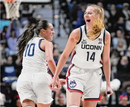  ?? Jessica Hill/Associated Press ?? UConn’s Nika Muhl (10) celebrates with Dorka Juhasz after Juhasz hit a 3-pointer against Florida State in December.