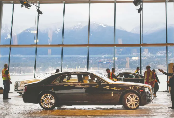  ?? — MARK VAN MANEN/PNG FILES ?? Crews manoeuvre a new Rolls-Royce Ghost into place in 2017 for the 97th edition of the Vancouver Internatio­nal Auto Show.