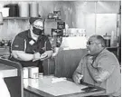  ?? RUSS BYNUM/AP ?? Corey Brooks orders food Monday at a Waffle House in Savannah, Georgia. Restaurant­s statewide were allowed to resume dine-in service with restrictio­ns.