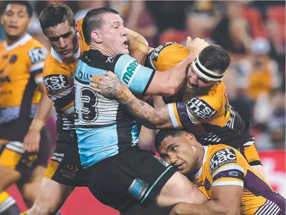  ??  ?? GOTCHA: Sharks forward Paul Gallen is wrapped up during last night’s clash against the Broncos at Suncorp Stadium.