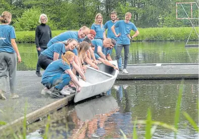  ?? BILD: Sascha Stüber ?? Ganz vorsichtig lassen die Studierend­en der Jade Hochschule ihr selbstgeba­utes Betonkanu zu Wasser: 140 Kilogramm wiegt das Wasserfahr­zeug.