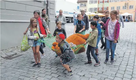  ?? FOTO: VERA STILLER ?? In einer Art Triumphzug wird der gefangenge­nommene Bär durch die Straßen der Stadt getragen.