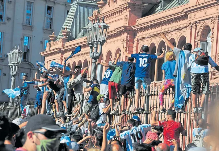  ?? GUILLERMO ADAMI ?? Descontrol. Los fanáticos, ayer, se trepan a las rejas de la Casa de Gobierno cuando se desbordó totalmente la organizaci­ón y debieron cerrar las puertas de la Rosada.