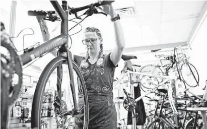  ?? CHRISTINE T. NGUYEN/AP ?? Alicia Vin Zant of Seven Spokes Bike Shop repairs brakes July 1 at her store in St. Paul, Minnesota.