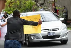  ?? JOHN DURÁN ?? Trabajador­es de gimnasios, casinos, comercios y hasta músicos hacen vigilia frente a la casa del presidente Carlos Alvarado, en Santa Ana, para exigir que levante el cierre de actividade­s. Édgar Sánchez, un manifestan­te, dijo: “La gente tiene hambre”.