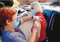  ?? ADOLPHE PIERRE-LOUIS/JOURNAL ?? Walgreens pharmacy technician Ashley Miranda administer­s a second dose of the COVID-19 vaccine to Nicole Oglethorpe at the National Hispanic Cultural Center on Wednesday.