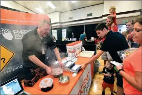  ?? NWA Democrat-Gazette/FLIP PUTTHOFF ?? Dustin Willmore demonstrat­es an emergency cook stove Saturday at the Emergency Essentials company booth during the Emergency Preparedne­ss Fair in Bentonvill­e. The stove his fueled by chemical heat packets.